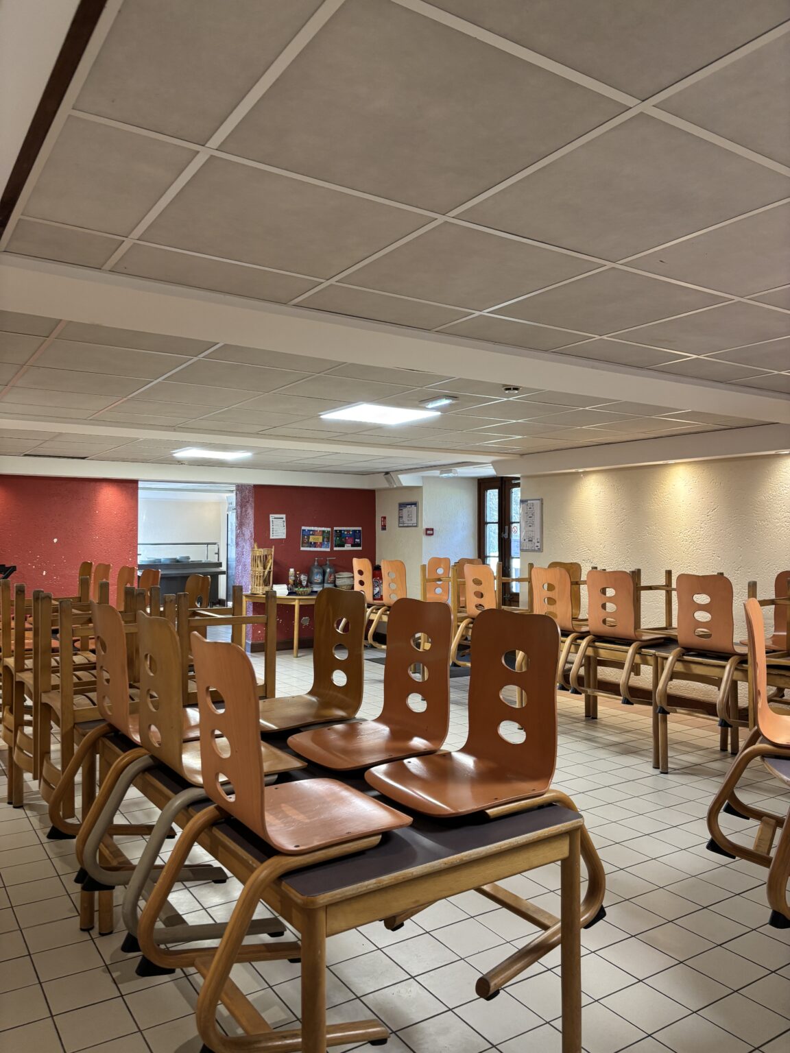 Salle du réfectoire avec ses tables et chaises